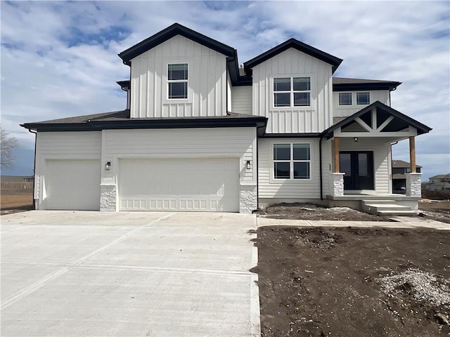 16941 S Brentwood St, Olathe, KS 66062 - view of front of property featuring driveway, a garage, board and batten siding, and stone siding