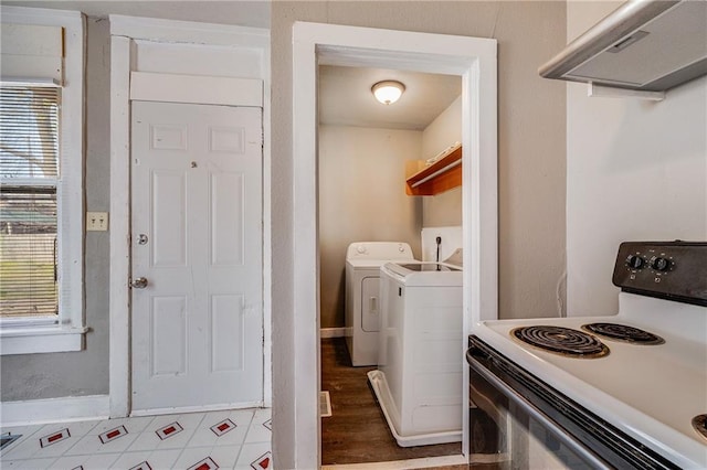 laundry area with washing machine and clothes dryer, baseboards, and wood finished floors