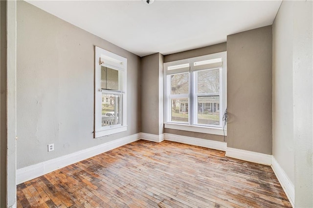 empty room with hardwood / wood-style flooring and baseboards