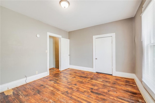 empty room featuring wood finished floors, baseboards, and a wealth of natural light