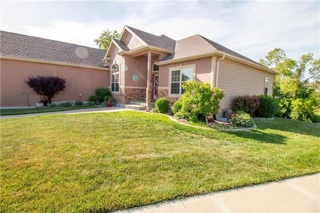 single story home with a front yard, stucco siding, and stone siding