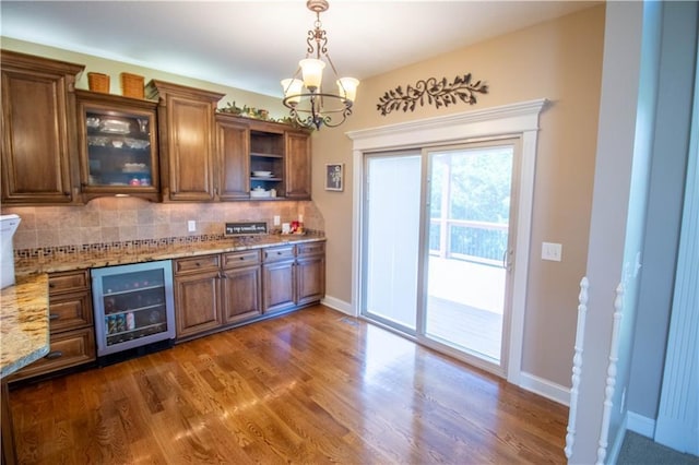 kitchen featuring beverage cooler, brown cabinetry, tasteful backsplash, and dark wood-style floors