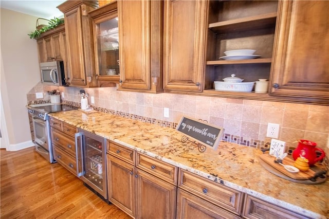 kitchen featuring wine cooler, stainless steel appliances, brown cabinets, and light stone counters