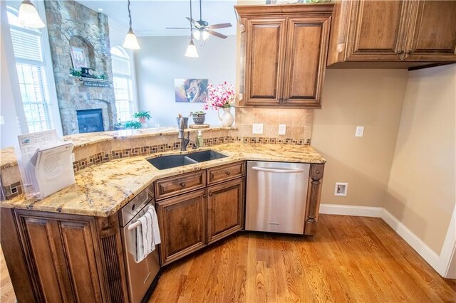 kitchen with dishwasher, a sink, light wood-type flooring, a peninsula, and ceiling fan