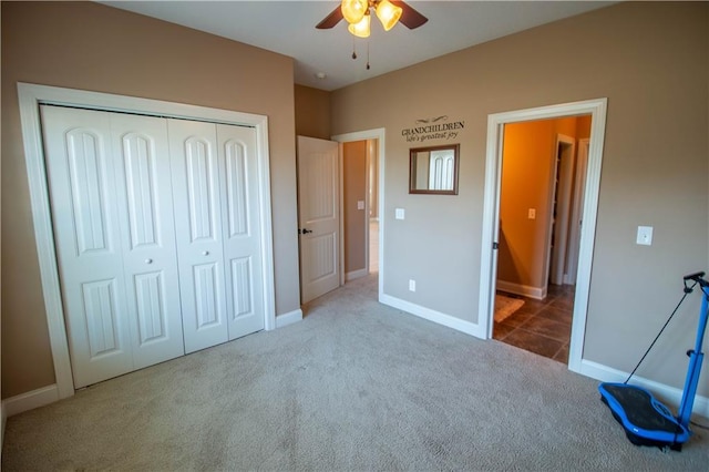 unfurnished bedroom with carpet floors, a closet, baseboards, and ceiling fan