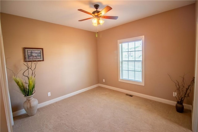 spare room with carpet floors, baseboards, and ceiling fan