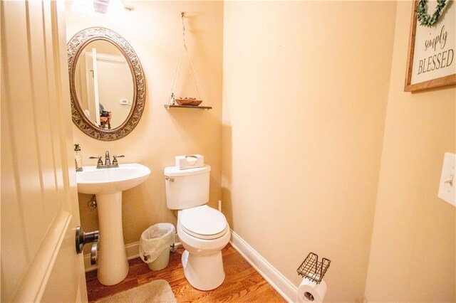 bathroom featuring wood finished floors, a sink, and toilet