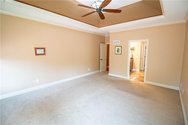 unfurnished bedroom with a raised ceiling, ornamental molding, light carpet, baseboards, and ceiling fan