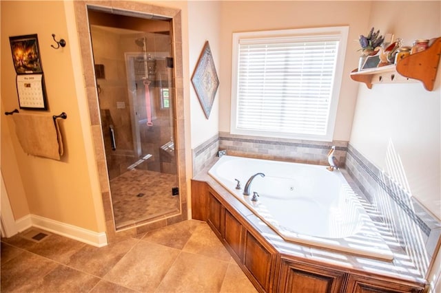 full bathroom with a stall shower, a tub with jets, baseboards, and tile patterned floors