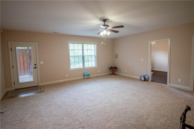 carpeted empty room featuring a ceiling fan and baseboards