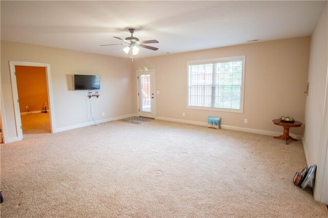 unfurnished living room with carpet, ceiling fan, and baseboards