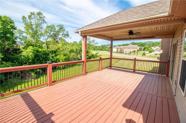 wooden terrace featuring a ceiling fan and a yard