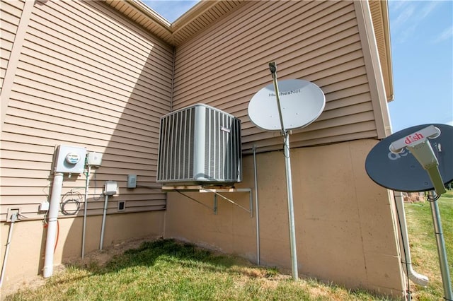 view of side of property featuring a yard and a cooling unit