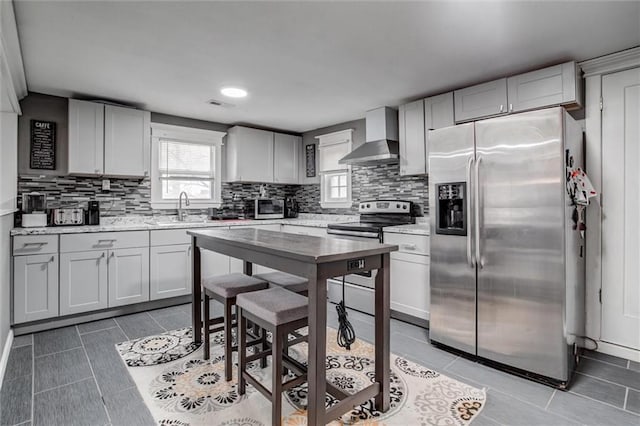 2915 Farrow Ave, Kansas City, KS 66104 - kitchen with backsplash, wall chimney range hood, a sink, light tile patterned flooring, and appliances with stainless steel finishes