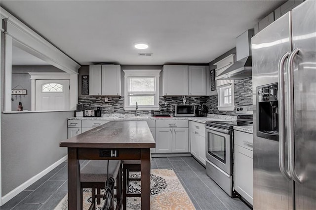 2915 Farrow Ave, Kansas City, KS 66104 - kitchen featuring backsplash, wall chimney range hood, stainless steel appliances, and a sink