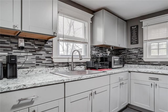 2915 Farrow Ave, Kansas City, KS 66104 - kitchen featuring light stone counters, tasteful backsplash, a sink, a toaster, and white cabinetry
