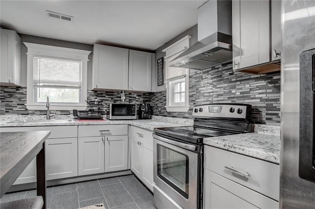 2915 Farrow Ave, Kansas City, KS 66104 - kitchen featuring wall chimney exhaust hood, a sink, stainless steel appliances, and a healthy amount of sunlight