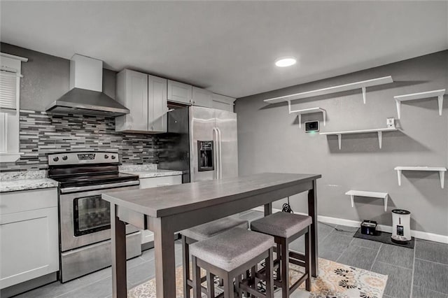 2915 Farrow Ave, Kansas City, KS 66104 - kitchen with wall chimney exhaust hood, stainless steel appliances, baseboards, decorative backsplash, and open shelves
