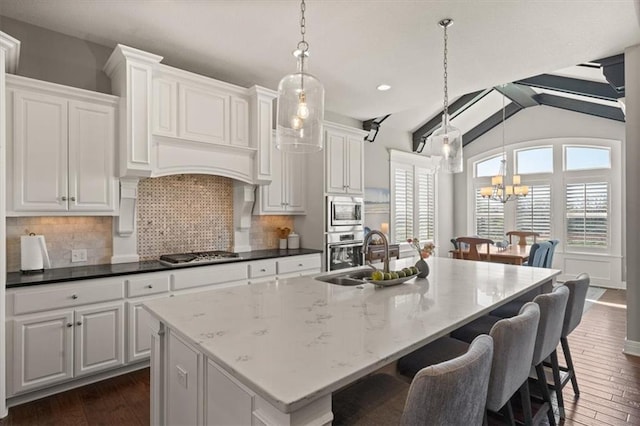 9874 Belmont Dr, Lenexa, KS 66227 - kitchen with appliances with stainless steel finishes, a sink, a chandelier, tasteful backsplash, and dark wood-style floors