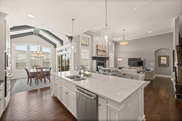 9874 Belmont Dr, Lenexa, KS 66227 - kitchen with stainless steel appliances, a sink, a glass covered fireplace, dark wood-type flooring, and a chandelier