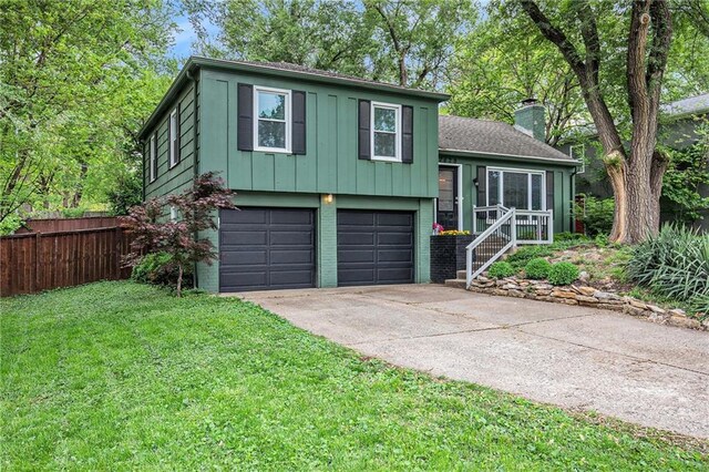 7620 Windsor St, Prairie Village, KS 66208 - split level home with a garage, a front lawn, fence, a chimney, and driveway