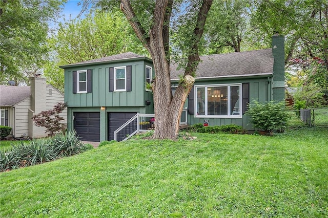 7620 Windsor St, Prairie Village, KS 66208 - tri-level home featuring an attached garage, board and batten siding, a front yard, and a chimney