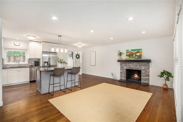 7620 Windsor St, Prairie Village, KS 66208 - kitchen with appliances with stainless steel finishes, a sink, a fireplace, a kitchen breakfast bar, and a kitchen island