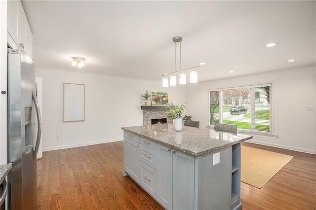 7620 Windsor St, Prairie Village, KS 66208 - kitchen featuring a center island, light stone countertops, stainless steel fridge with ice dispenser, baseboards, and dark wood-style floors