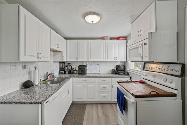 1340 E 85th St, Kansas City, MO 64131 - kitchen with white appliances, a textured ceiling, white cabinetry, light wood-style flooring, and decorative backsplash