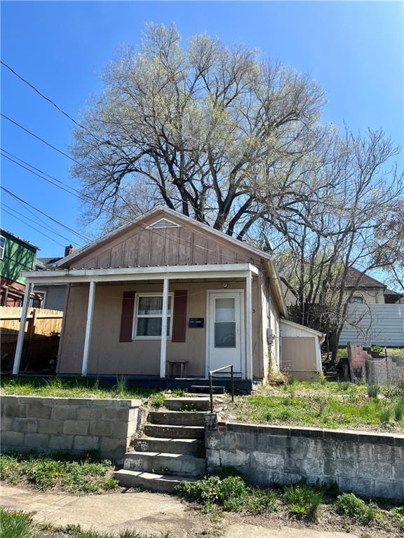 913 Vine St, Saint Joseph, MO 64503 - bungalow with board and batten siding, fence, and covered porch
