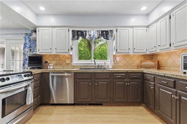 16524 Horton St, Stilwell, KS 66085 - kitchen featuring appliances with stainless steel finishes, a sink, dark brown cabinets, white cabinetry, and recessed lighting