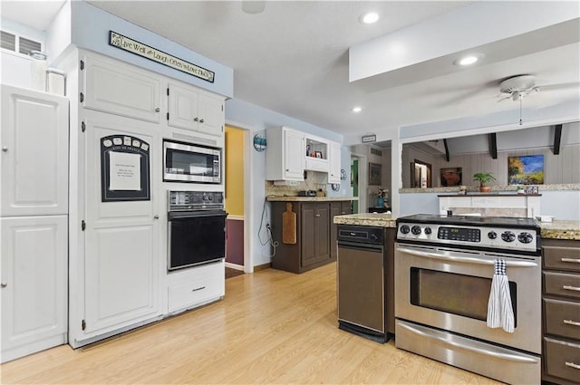 16524 Horton St, Stilwell, KS 66085 - kitchen with stainless steel appliances, white cabinetry, light wood-style flooring, light stone counters, and recessed lighting