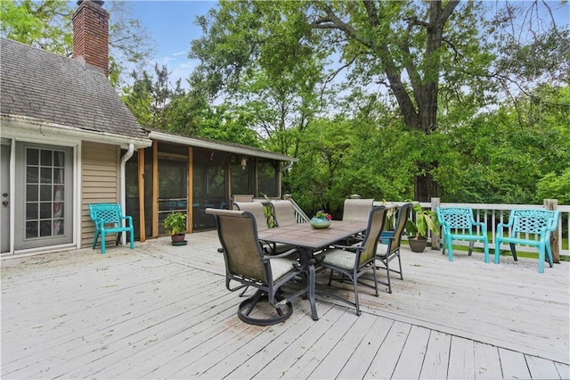 16524 Horton St, Stilwell, KS 66085 - wooden deck with outdoor dining area, a sunroom, and view of wooded area