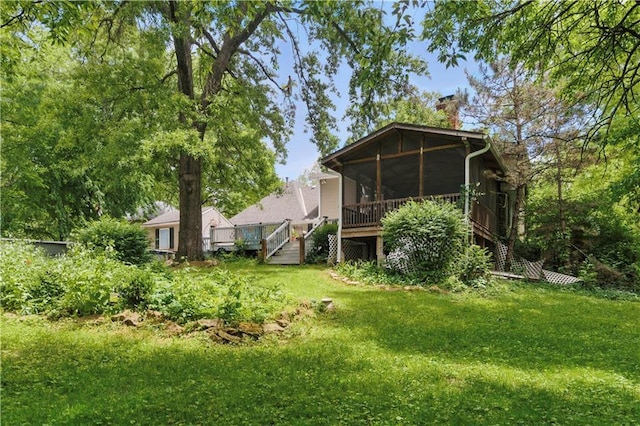 16524 Horton St, Stilwell, KS 66085 - rear view of property with a chimney, a lawn, a sunroom, and a wooden deck