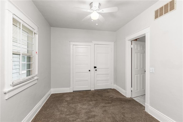 spare room with carpet flooring, baseboards, ceiling fan, and visible vents