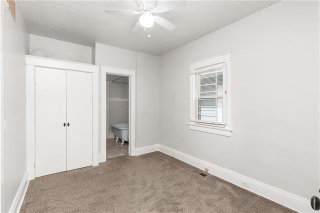 unfurnished bedroom with carpet flooring, ensuite bathroom, baseboards, and a closet