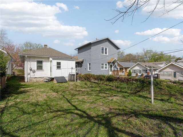 rear view of property with a chimney and a yard