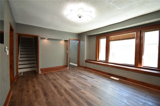 4015 Benton Blvd, Kansas City, MO 64130 - spare room with wood finished floors, stairs, and a textured ceiling
