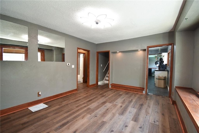 4015 Benton Blvd, Kansas City, MO 64130 - empty room with wood finished floors, stairs, and a textured ceiling