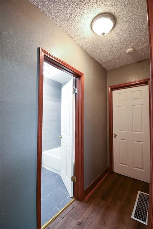 4015 Benton Blvd, Kansas City, MO 64130 - hallway featuring dark wood-type flooring and a textured ceiling