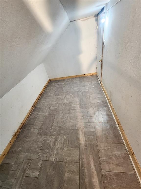 4015 Benton Blvd, Kansas City, MO 64130 - additional living space featuring vaulted ceiling and baseboards