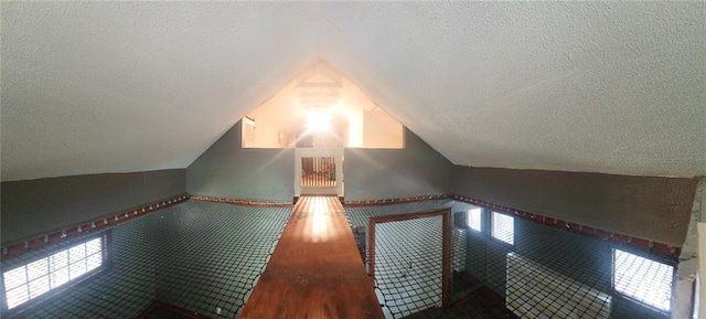4015 Benton Blvd, Kansas City, MO 64130 - bonus room featuring a textured ceiling, vaulted ceiling, and wood finished floors