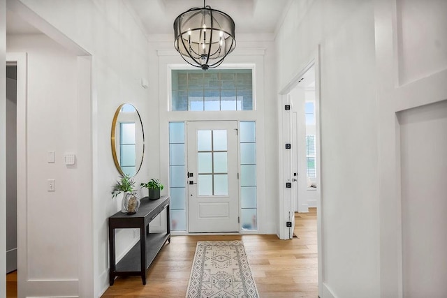 entrance foyer featuring an inviting chandelier and light wood-style floors
