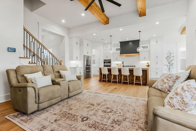 living room featuring recessed lighting, a ceiling fan, light wood-type flooring, and beam ceiling