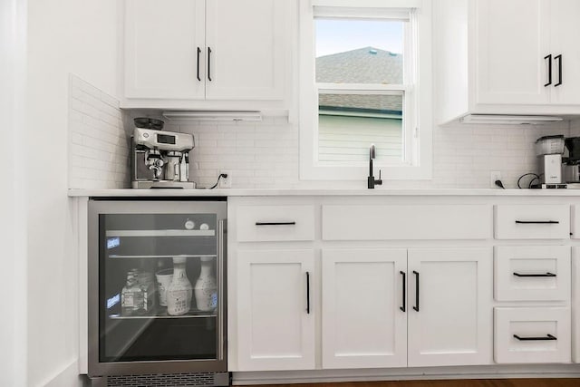 bar featuring a sink, wine cooler, and backsplash