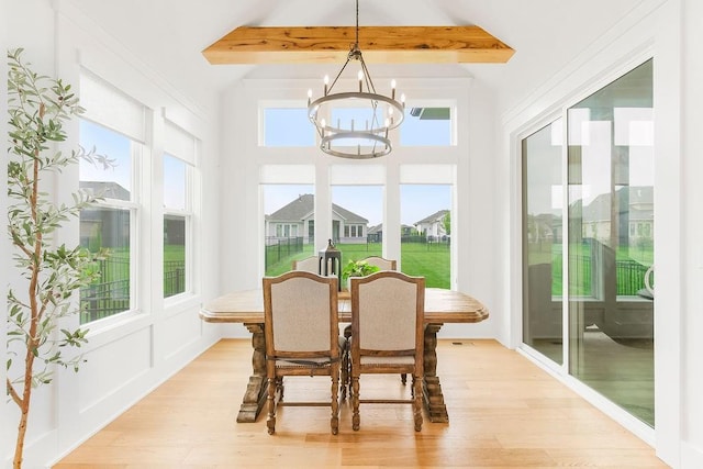 sunroom featuring beam ceiling and a notable chandelier