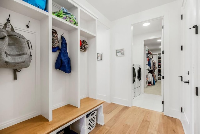 mudroom with recessed lighting, baseboards, washing machine and dryer, and light wood-style flooring