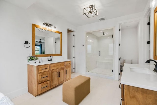 bathroom with visible vents, vanity, baseboards, ceiling fan, and a stall shower