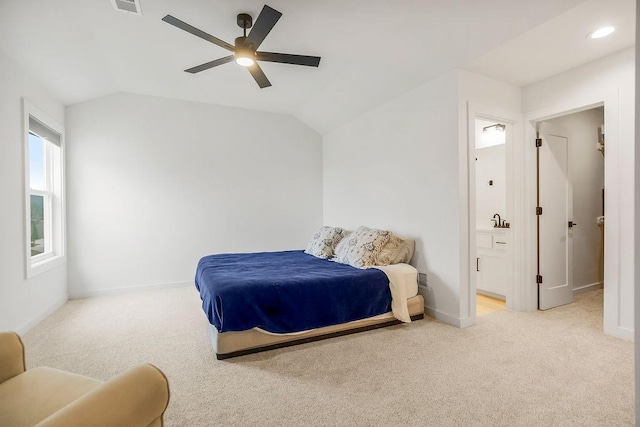 bedroom featuring ensuite bath, carpet, a ceiling fan, baseboards, and vaulted ceiling