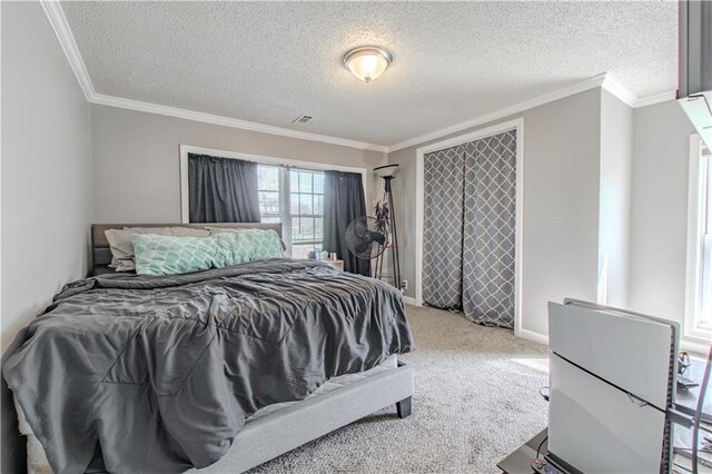carpeted bedroom with baseboards, visible vents, ornamental molding, and a textured ceiling
